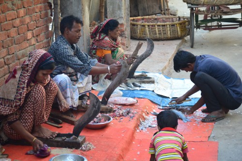 Some working men and women processing some of the fish by the roadside in Dhanmondi.