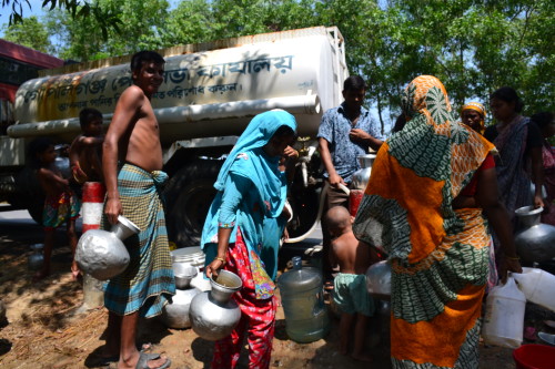 Men, women and children queue up for water next to the Gopalganj municipality water truck