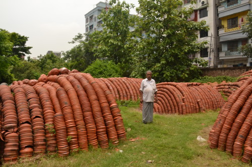 A shop owner stockpiles earthen pots used to sell halim during the month of Ramadan, in the city's Rayer Bazaar area.