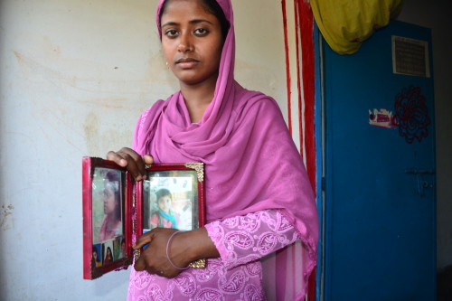 Shirin begum, holding out pictures of her missing daughter Rumi, and her other children