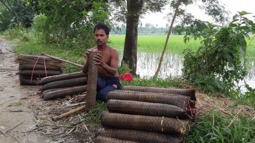 Ganesh preparing his fresh traps with bait so as to position them in the water bodies of Keraniganj