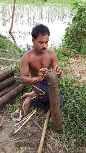 Ganesh preparing his fresh traps with bait so as to position them in the water bodies of Keraniganj