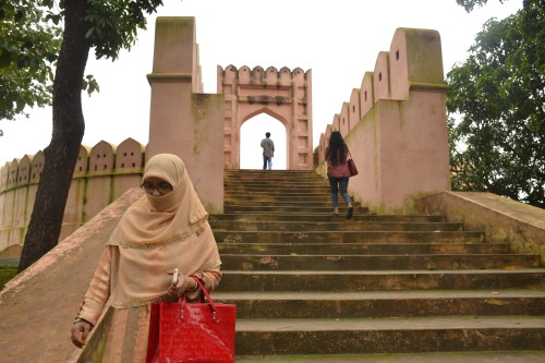 A woman walks down the steps from the fort. 