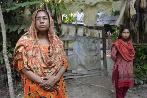 Hosneara Koli and her daughter in front of their house.