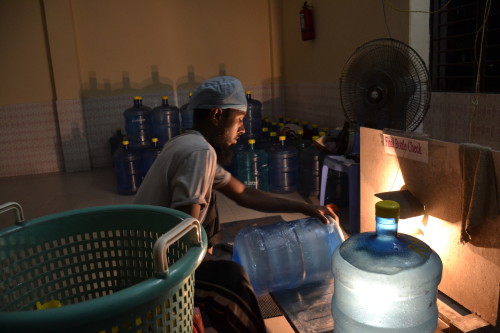 A worker carries out the final inspection on a water container at the Safa water purification centre