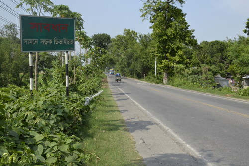 A roadside sign mentioning that there are barriers ahead, but having no fluorescent paint to warn motorists at night.