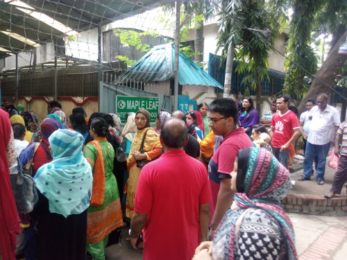 Parents line up outside a school in the Dhanmondi area of the capital