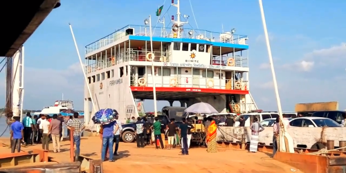 Officials escorting a VIP from a ferry at Mawa